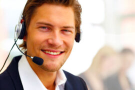 Freundlich lächelnder Mann mit Telefon-Headset